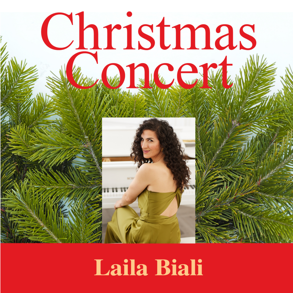 A woman with long curly hair in an olive green dress sits at a white piano, framed by lush green pine branches. The words "Christmas Concert" are printed in large red serif font at the top, with "Laila Biali" centered in gold on a red banner below.